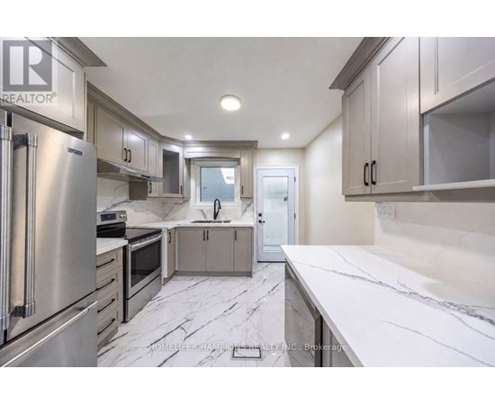 A modern kitchen with stainless steel appliances and marble countertops.