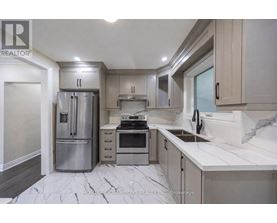 A modern kitchen with a marble floor and stainless steel appliances.