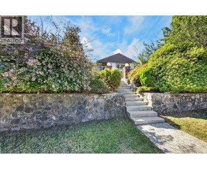 A stone wall with a staircase leading to a house.