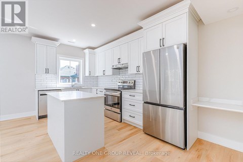 A modern kitchen with white cabinets and stainless steel appliances.