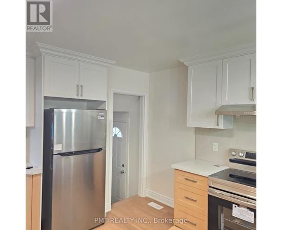 A kitchen with white cabinets and a stainless steel refrigerator.