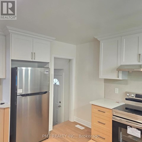 A kitchen with white cabinets and a stainless steel refrigerator.
