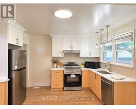 A kitchen with a black fridge and stove top oven.