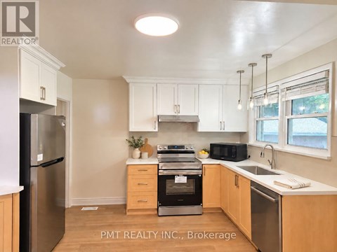 A kitchen with a black fridge and stove top oven.