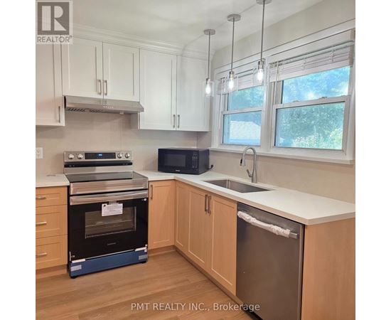 A kitchen with a stainless steel refrigerator and wooden cabinets.
