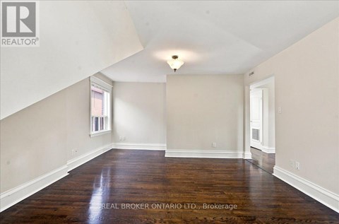 A spacious room with wooden floors and white walls.