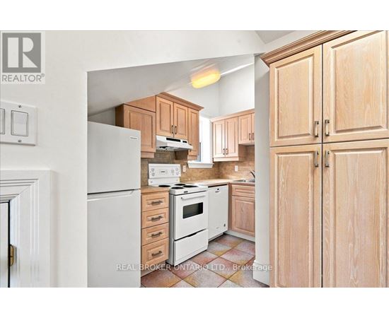 A kitchen with wooden cabinets and a white refrigerator.