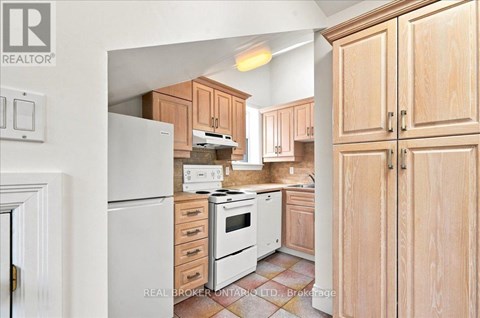 A kitchen with wooden cabinets and a white refrigerator.