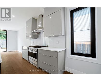 A modern kitchen with white cabinets and stainless steel appliances.