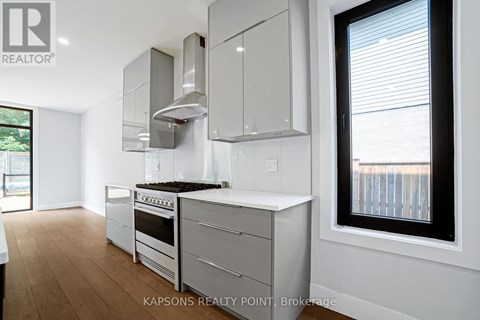 A modern kitchen with white cabinets and stainless steel appliances.