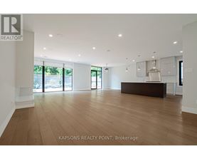 A spacious room with wooden flooring and a reception desk.