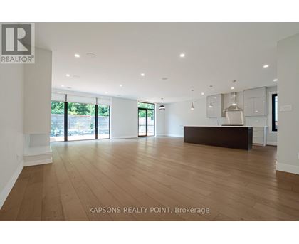 A spacious room with wooden flooring and a reception desk.