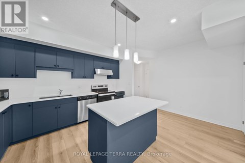 A modern kitchen with dark blue cabinets and a white island.
