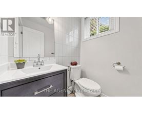 A bathroom with a sink, toilet, and a window.
