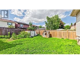 A backyard with a small wooden structure and a fence.