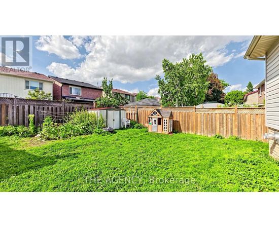 A backyard with a small wooden structure and a fence.