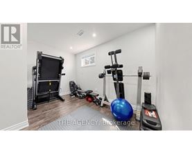 A room with a blue exercise ball, a black treadmill, and a black weight machine.