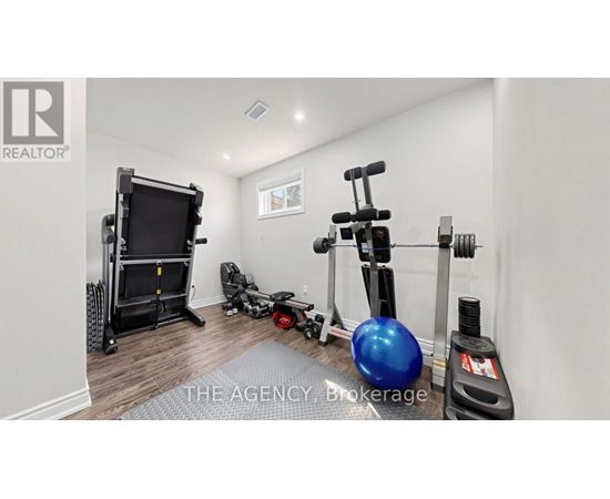 A room with a blue exercise ball, a black treadmill, and a black weight machine.