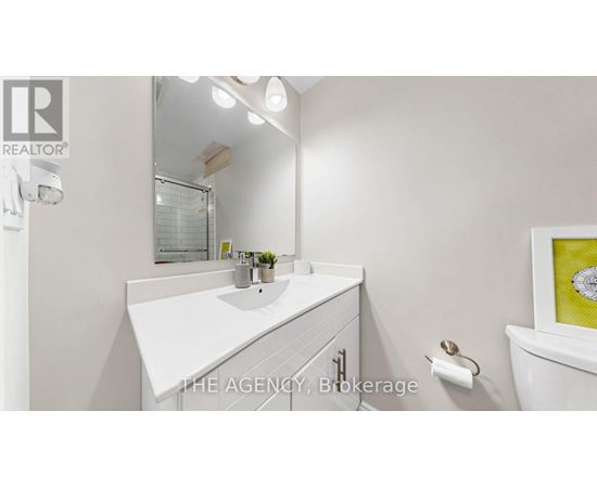 A white bathroom with a sink and mirror.