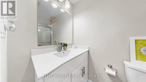 A white bathroom with a sink and mirror.