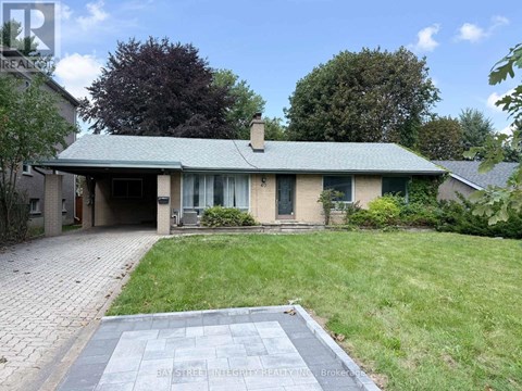 A house with a green roof and a brick driveway is for sale.