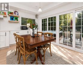 A dining room with a wooden table and chairs.