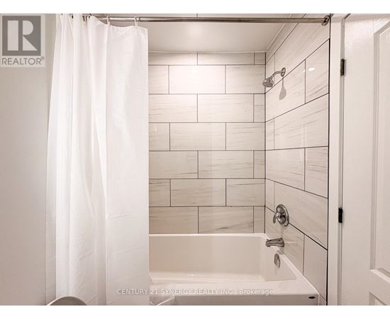 A white bathroom with a shower curtain and a bathtub.