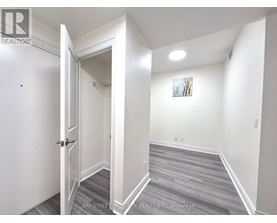 A hallway with a door on the left and a painting on the wall.