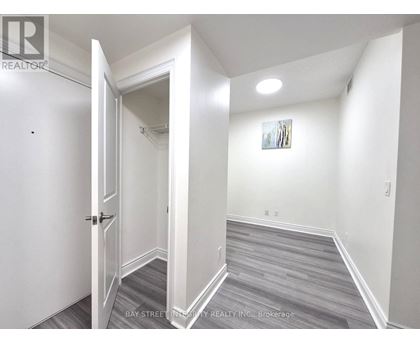 A hallway with a door on the left and a painting on the wall.