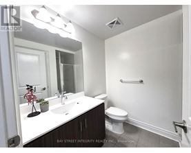 A white sink and toilet in a small bathroom.