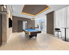 A room with a pool table and a bar stool.