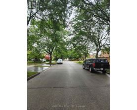 A wet street with a truck and a car on it.