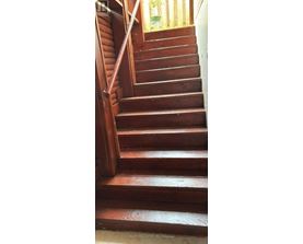 A wooden staircase with a handrail on the left side.