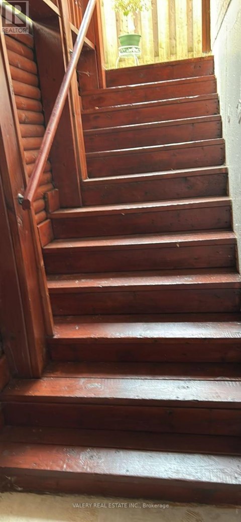 A wooden staircase with a handrail on the left side.