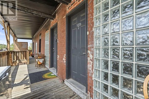 A house with a black door and windows covered in plastic.
