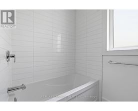 A white bathroom with a bathtub and a window.