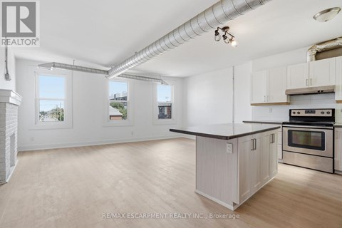 A kitchen with white cabinets and a black countertop.