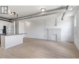 A spacious room with a fireplace and a bar area.