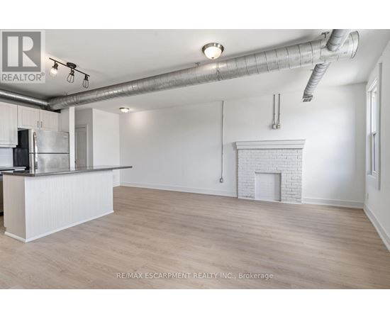 A spacious room with a fireplace and a bar area.