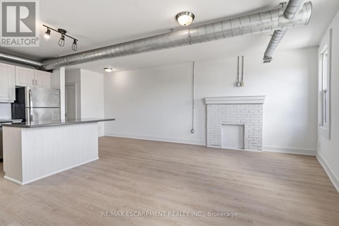 A spacious room with a fireplace and a bar area.
