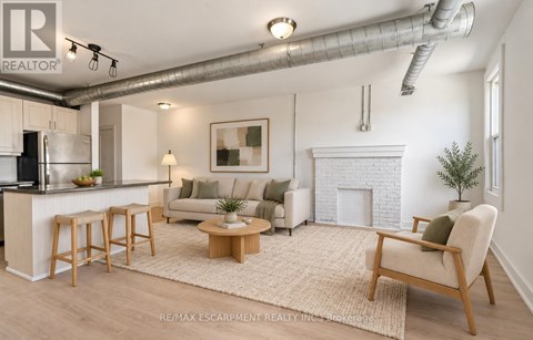 A well-lit living room with a fireplace and a bar area.