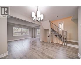 A spacious living room with a staircase leading to the upper floor.