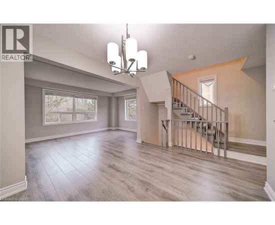 A spacious living room with a staircase leading to the upper floor.