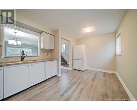A kitchen with white cabinets and a wooden floor.