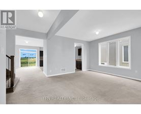 A spacious room with a sliding glass door leading to a balcony.