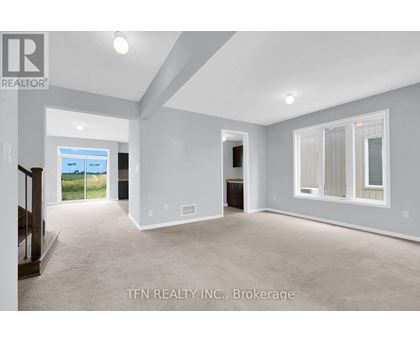 A spacious room with a sliding glass door leading to a balcony.