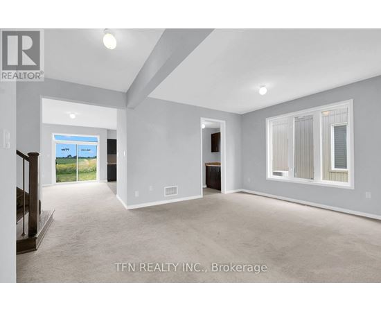 A spacious room with a sliding glass door leading to a balcony.