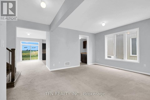 A spacious room with a sliding glass door leading to a balcony.