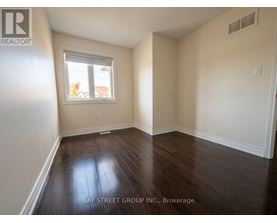 A room with a window and wooden flooring.