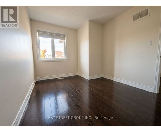 A room with a window and wooden flooring.